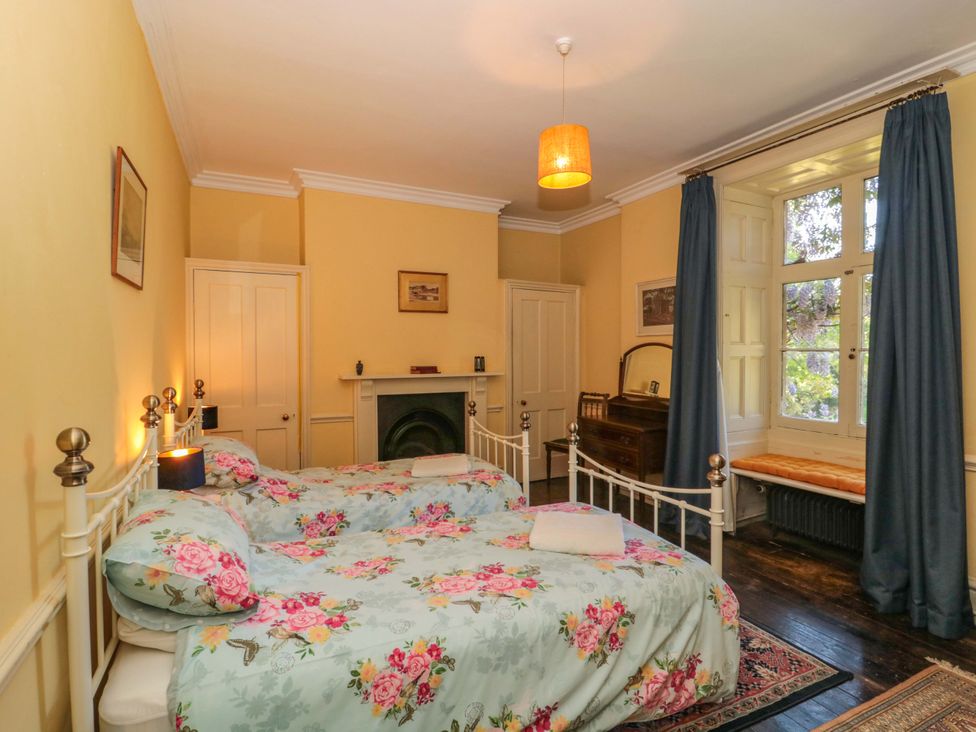 A bedroom with two beds and a window at The West Wing 