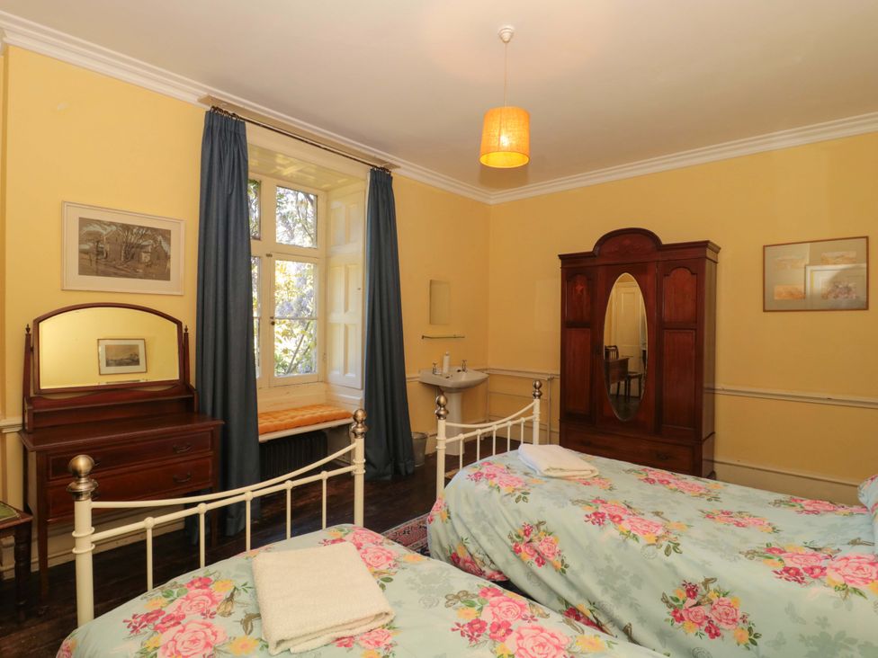 A bedroom with two beds and a wardrobe at The West Wing