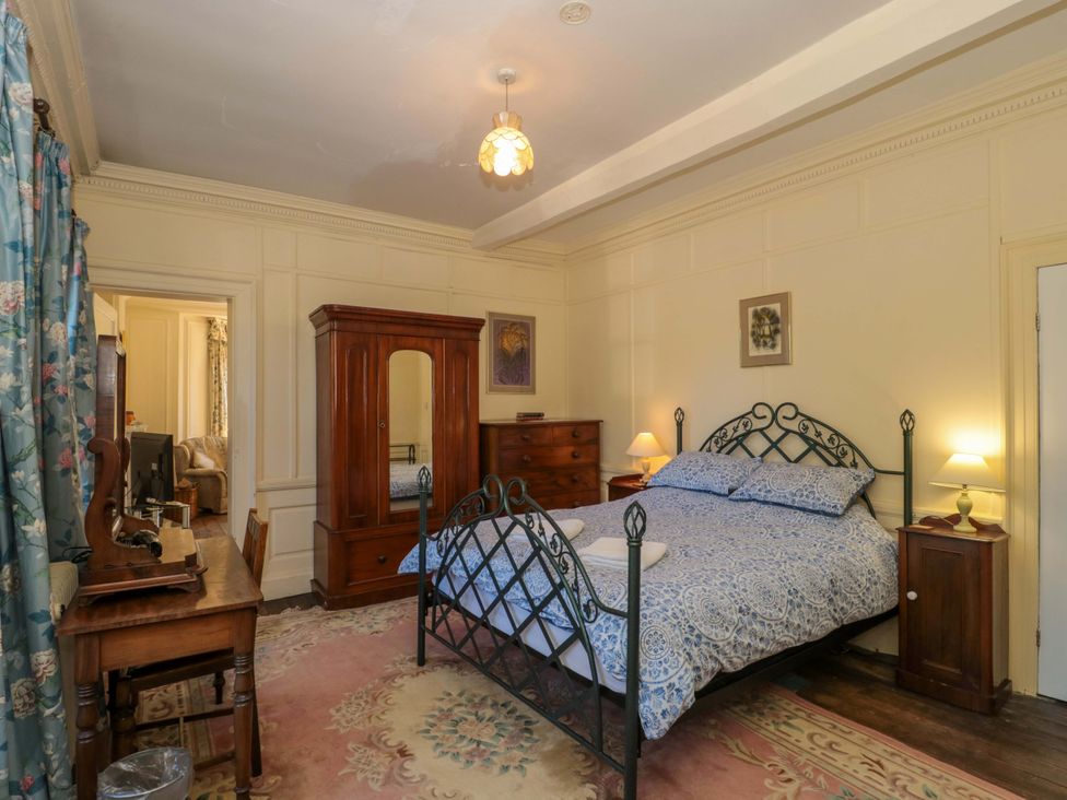A bedroom with a bed and wooden furniture at The West Wing