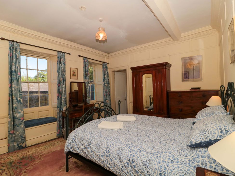 A bedroom with a bed and a wardrobe at The West Wing 
