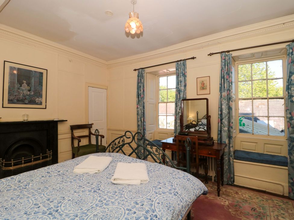 A bedroom with a bed and dressing table at The West Wing