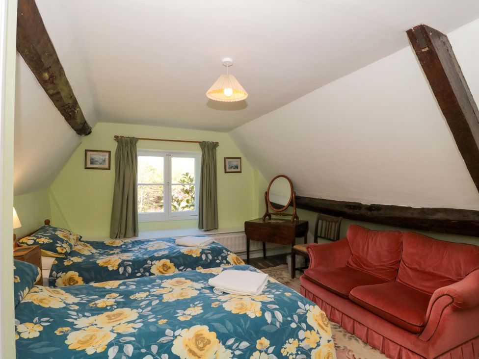 A bedroom with two beds and a mirror at The West Wing 