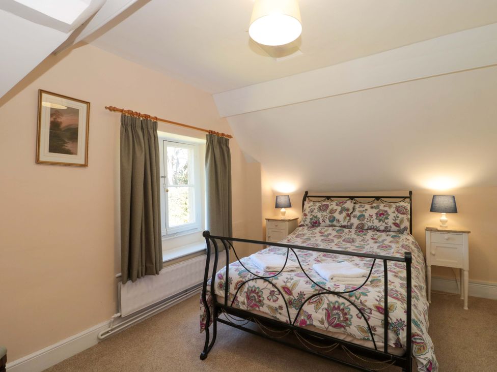 A bedroom with a bed and bedside tables at The West Wing 