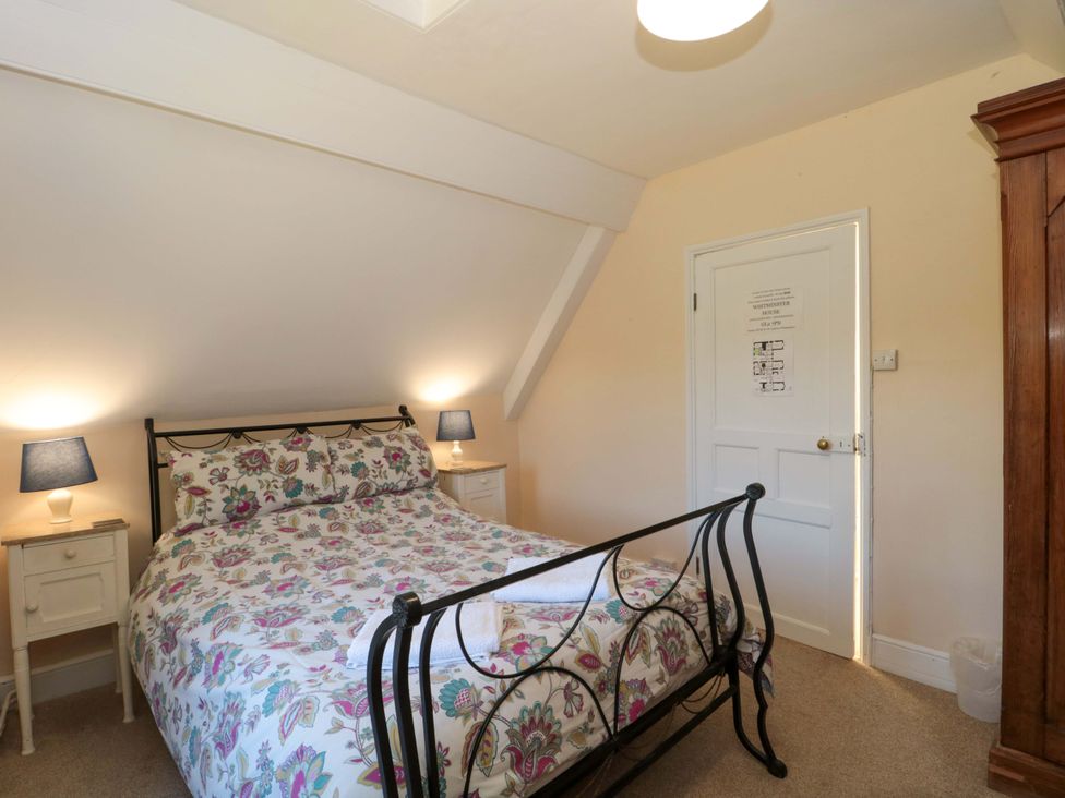 A bedroom with a bed and nightstands at The West Wing 