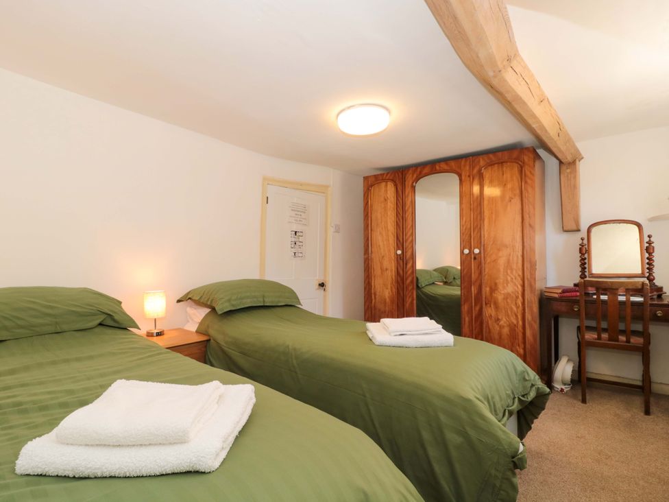 A bedroom with two beds and a wardrobe at The West Wing
