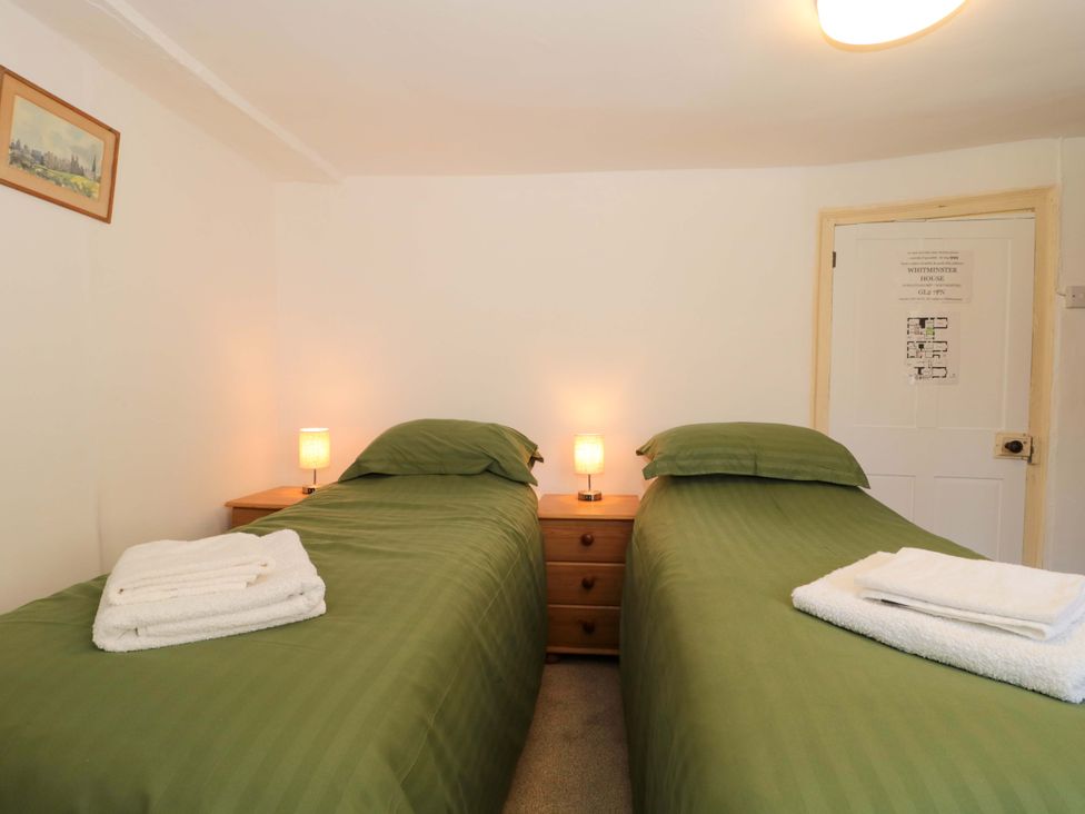 A bedroom with twin beds and a lamp at The West Wing in 