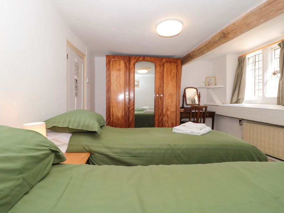 A bedroom with two beds and a wardrobe at The West Wing 