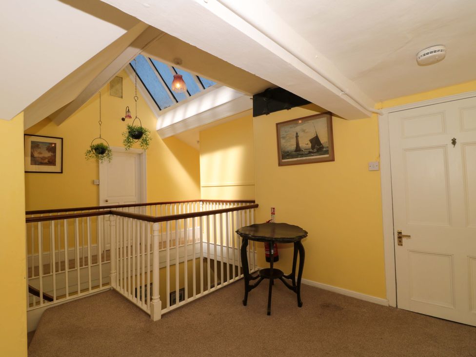 A landing with a staircase and a table at The West Wing 