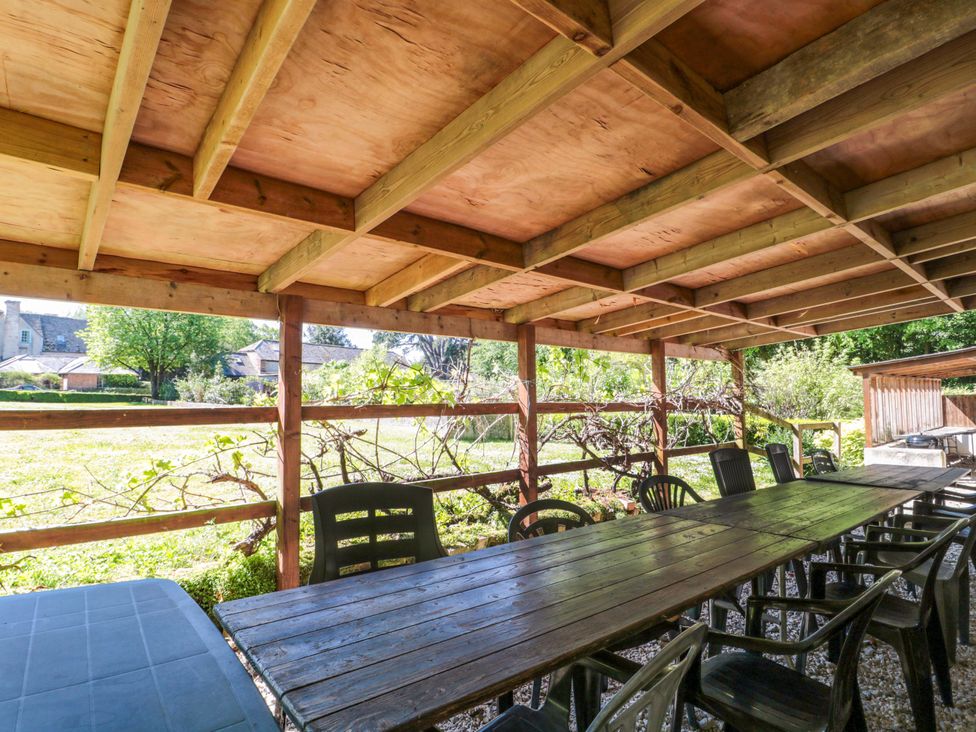 An outdoor dining area with a long table and chairs at The West Wing