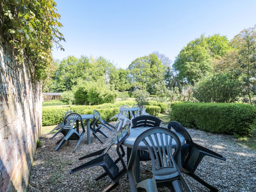 A garden with tables and chairs set on gravel at The West Wing 