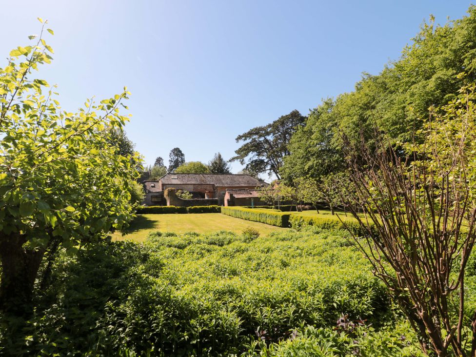 A garden with hedges and a building in the background at The West Wing 