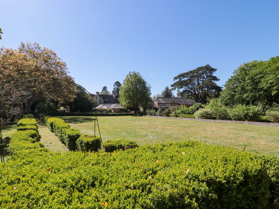 A garden area with hedges and trees at The West Wing 