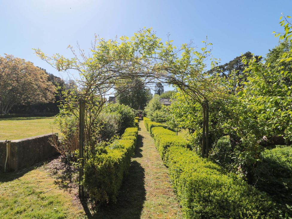 A garden with hedges and an archway at The West Wing