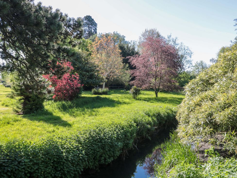 A garden with trees and a stream at The West Wing 