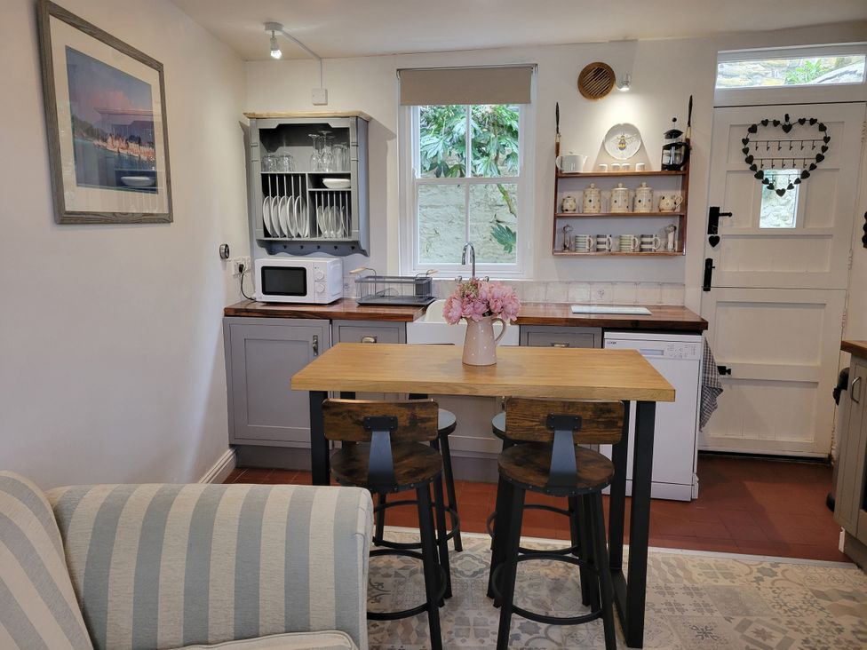 A kitchen with a table and chairs at Millgate Cottage in Conwy