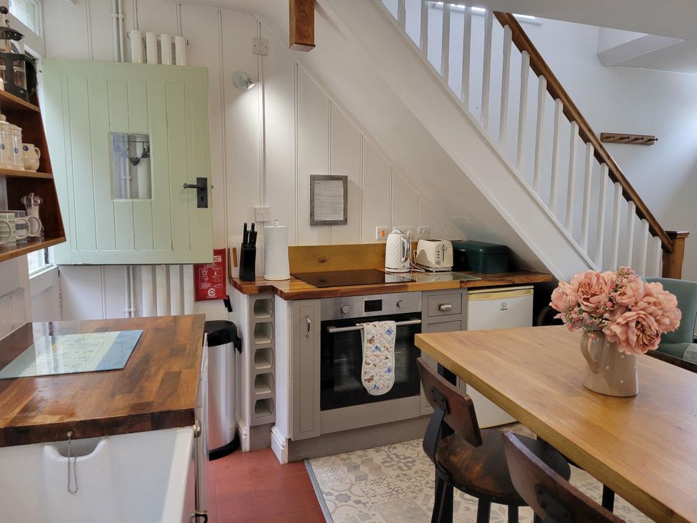 A kitchen with wooden table and chairs at Millgate Cottage in Conwy