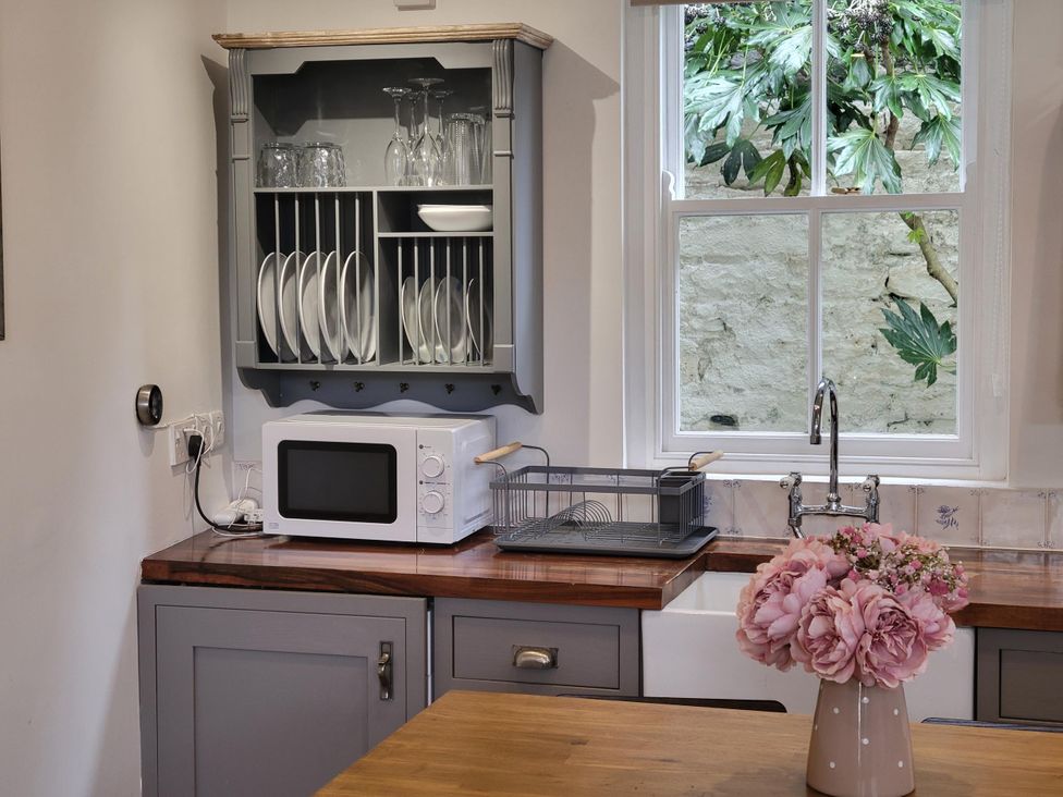 A kitchen with a microwave and sink at Millgate Cottage in Conwy