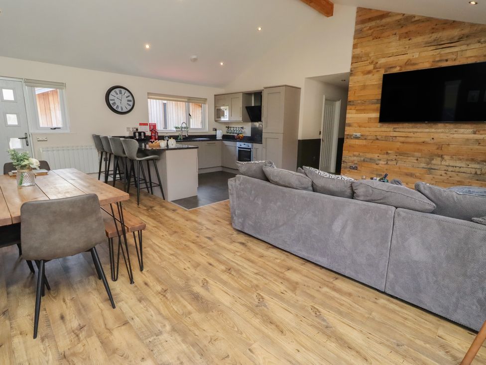 A living room with a sofa and dining area at Barn Owl in Otterburn
