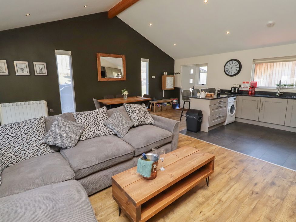 A living room with kitchen and dining area at Barn Owl in Otterburn