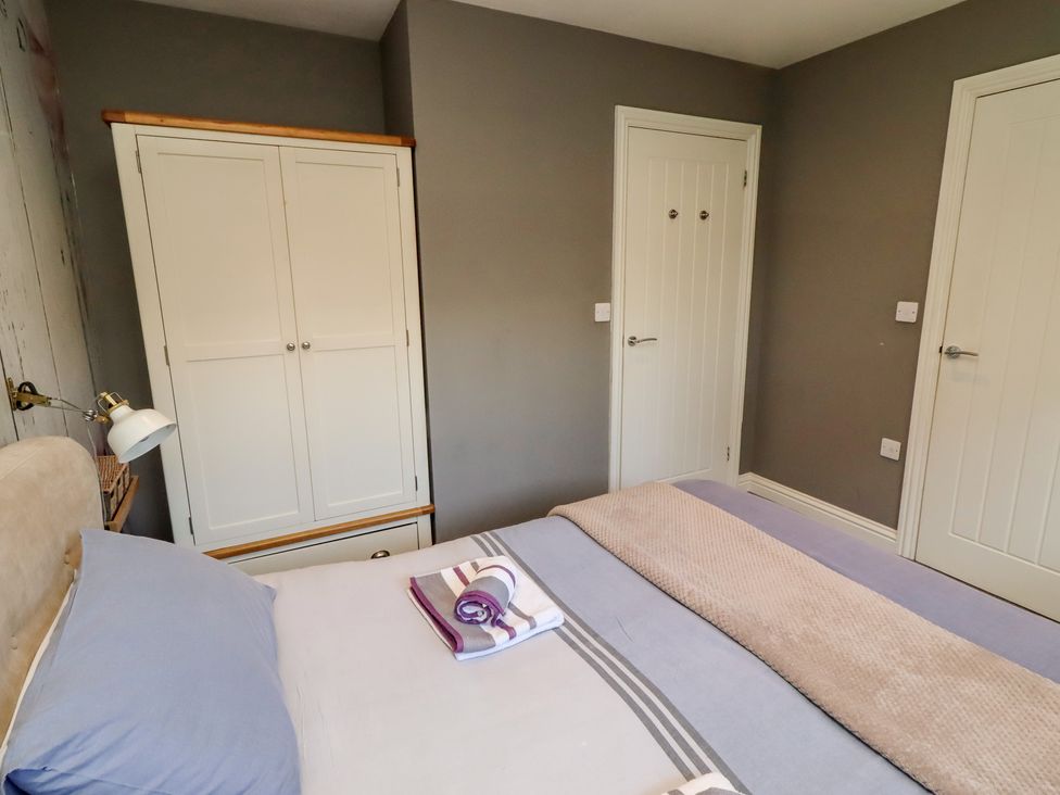 A bedroom with a bed and wardrobe at Barn Owl in Otterburn