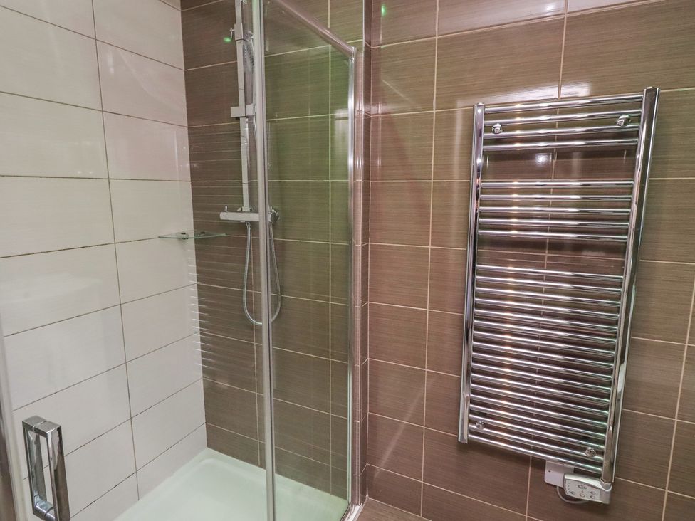 A bathroom with a shower and towel rail at Barn Owl in Otterburn