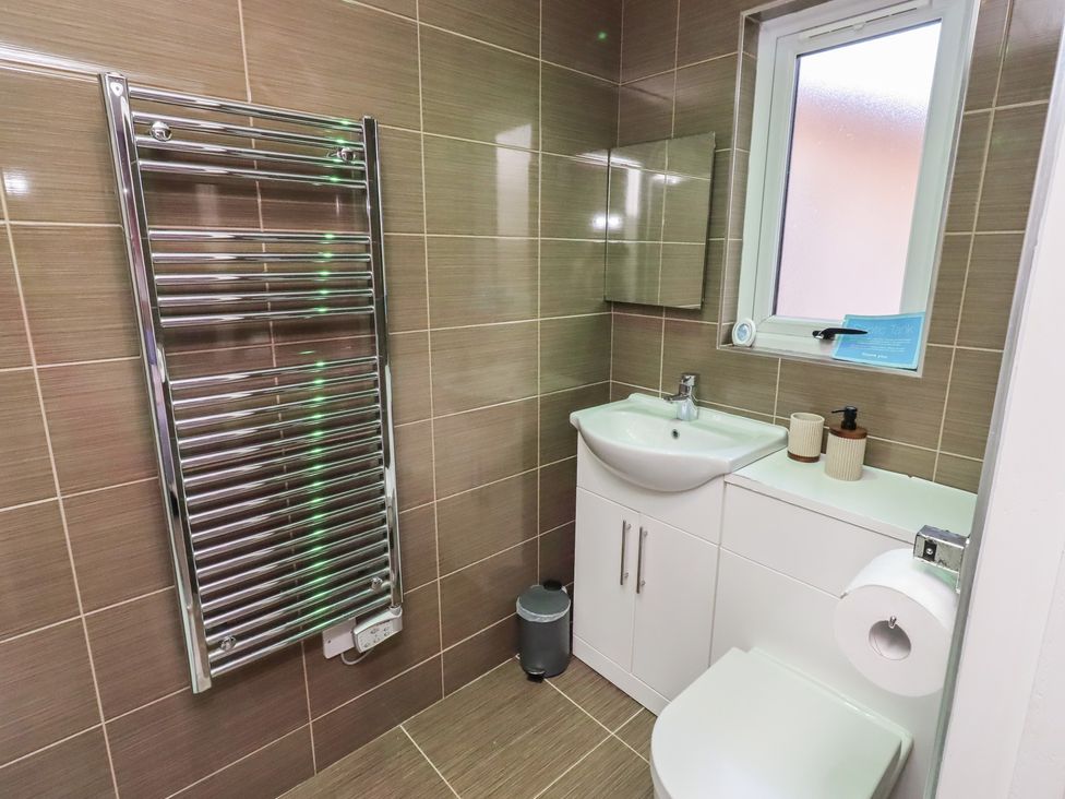 A bathroom featuring a sink, toilet, and a radiator at Barn Owl in Otterburn