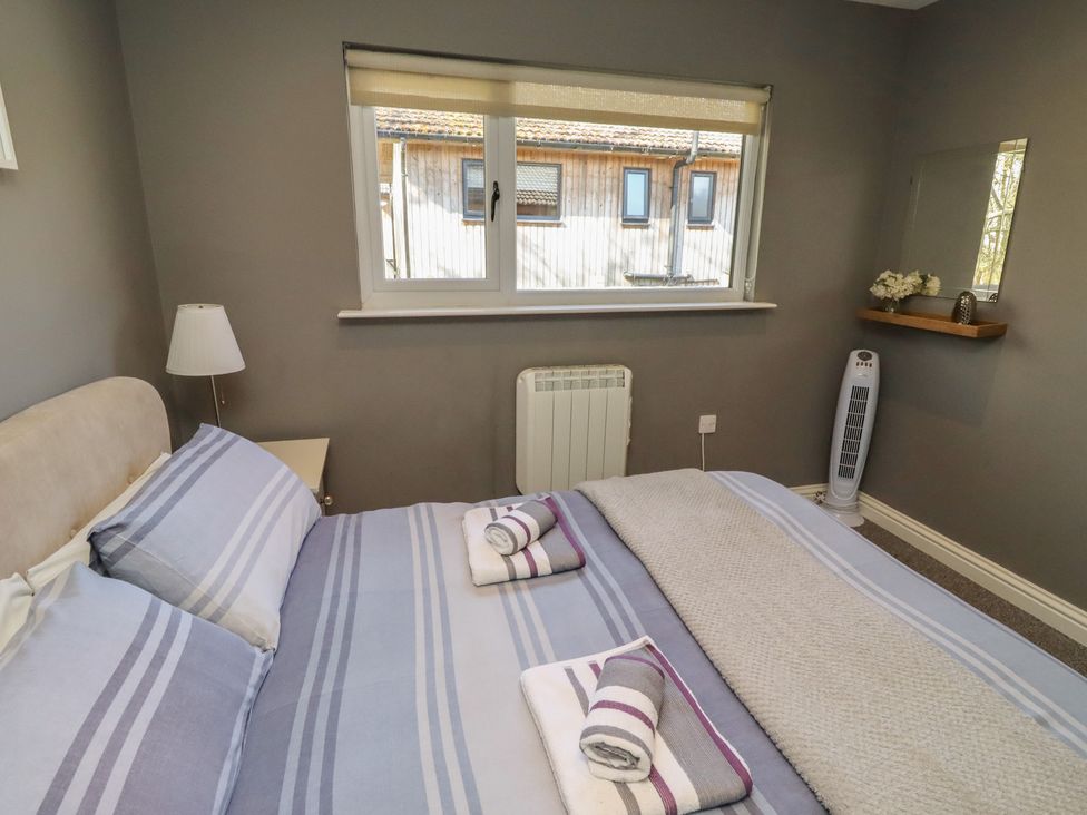 A bedroom with a bed and window at Barn Owl in Otterburn