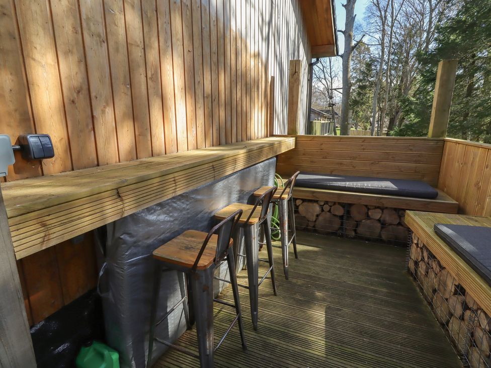 An outside deck with a bar counter and stools at Barn Owl in Otterburn