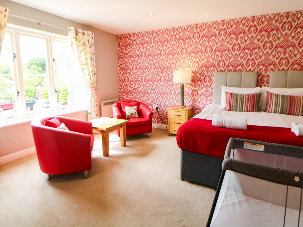 A bedroom with red chairs and a bed at Hassop in Matlock