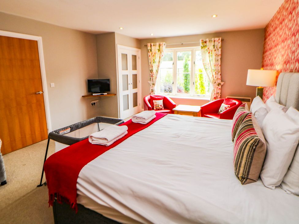 A bedroom with a bed and television at Hassop in Matlock