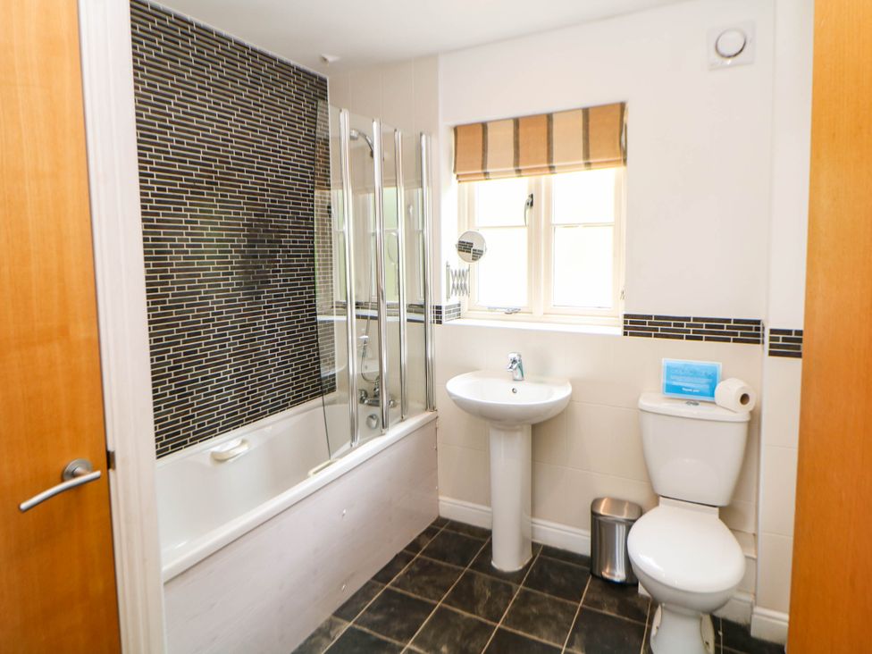 A bathroom with a bathtub, sink, and toilet at Hassop in Matlock