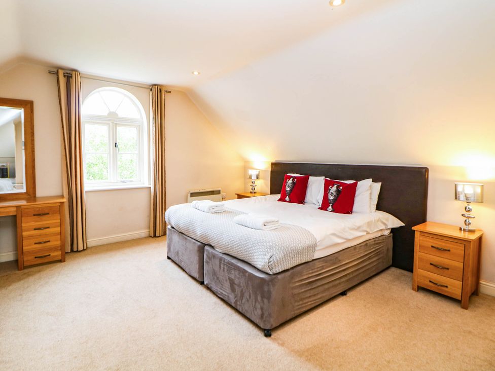 A bedroom with a bed and mirror at Hassop in Matlock