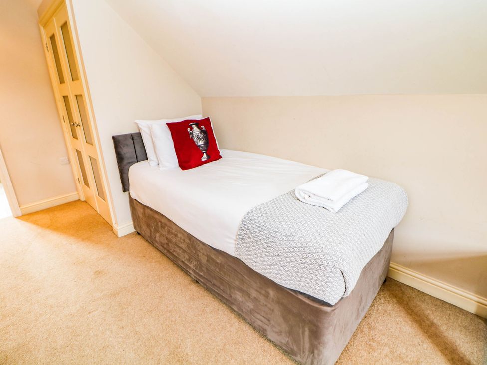 A single bed with a pillow and towels in a bedroom at Hassop Matlock