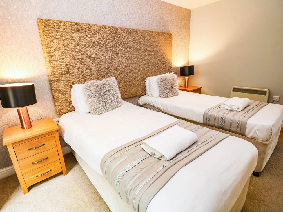 A bedroom with two single beds and nightstands at Hassop in Matlock