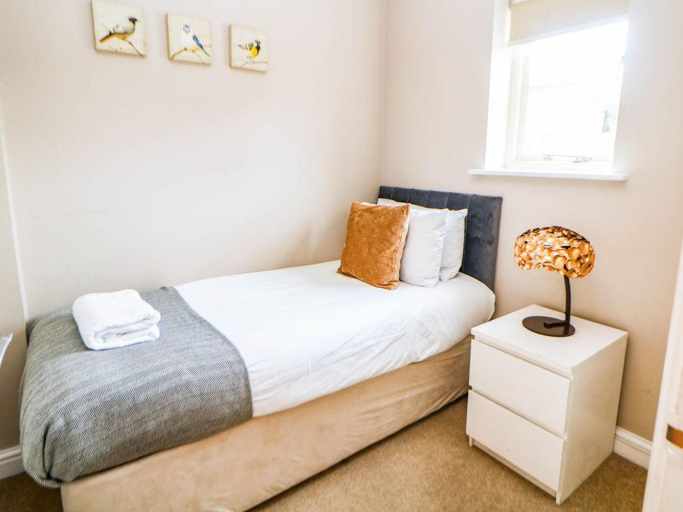 A bedroom with a single bed and bedside table at Hassop in Matlock
