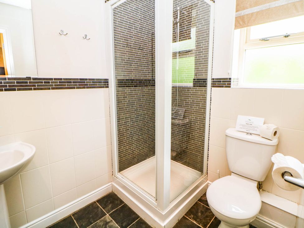 A bathroom featuring a shower, toilet, and sink at Hassop in Matlock