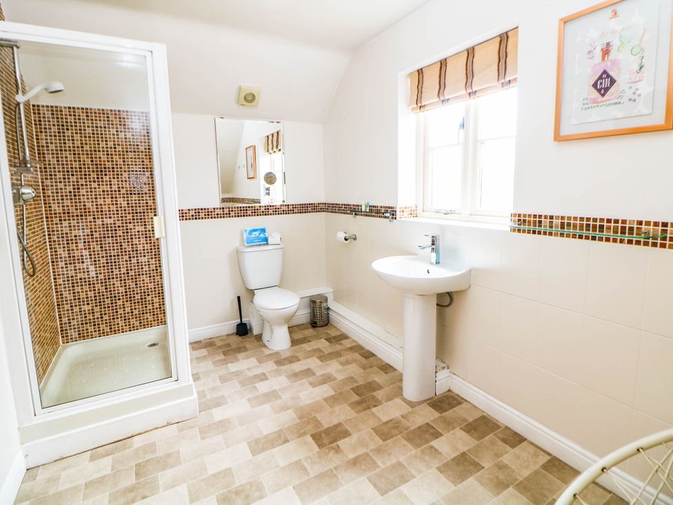 A bathroom with a shower, toilet, and sink at Hassop in Matlock