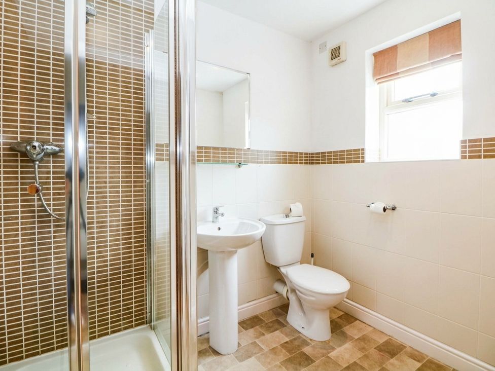 A bathroom with a shower, sink, and toilet at Hassop in Matlock