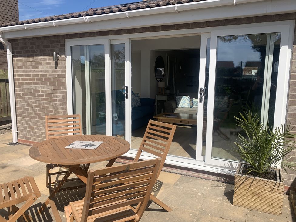 An outdoor patio with a table and chairs at The Nest in Beadnell