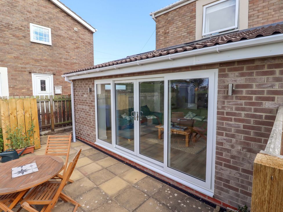 A garden with a table and chairs at The Nest in Beadnell