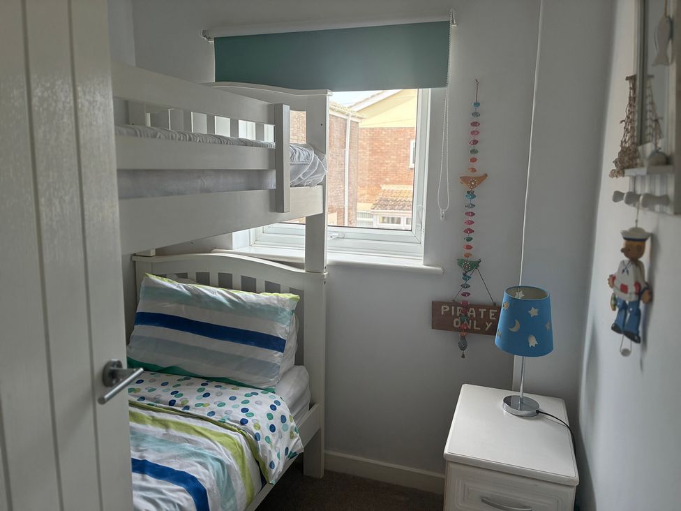 A bedroom with a bunk bed and a lamp at The Nest in Beadnell