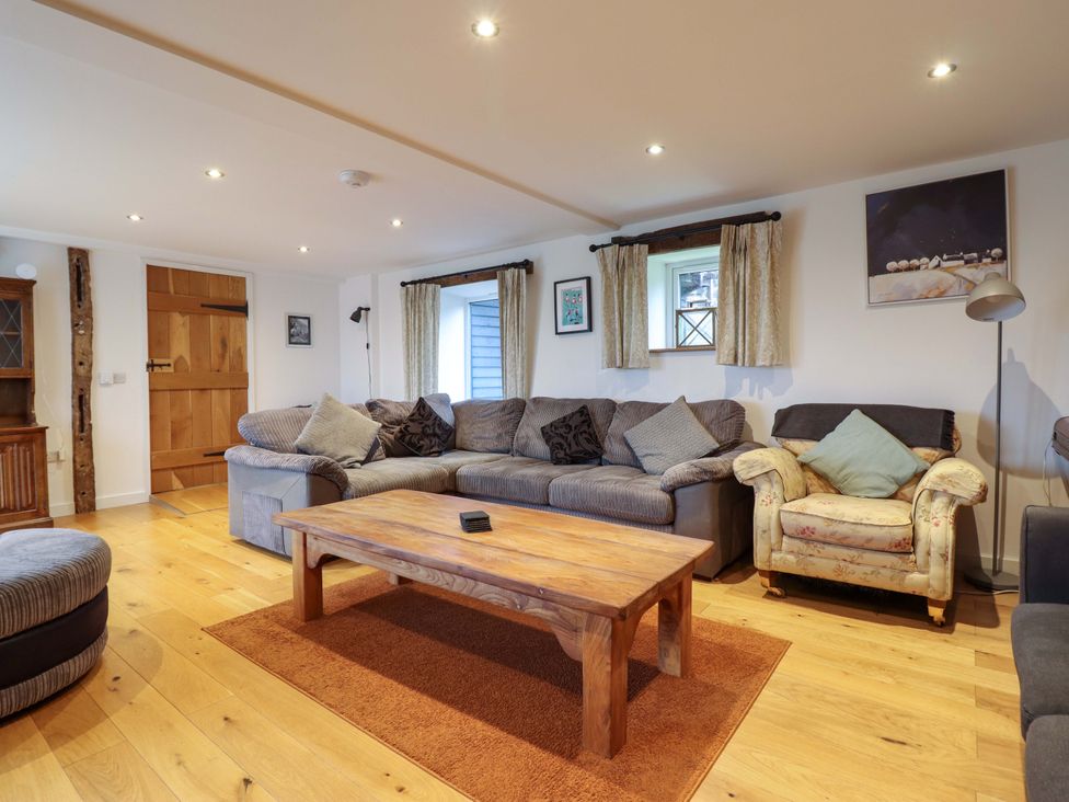 A living room with a sofa and coffee table at Bwthyn Y Bugail (Shepherd's Cottage) Pedairffordd near Llanrhaeadr-Ym-Mochnant