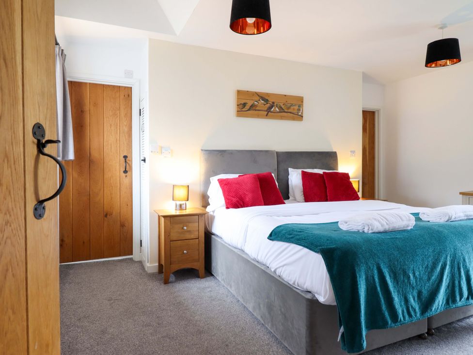 A bedroom with a double bed and nightstand at Bwthyn Y Bugail (Shepherd's Cottage) Pedairffordd near Llanrhaeadr-Ym-Mochnant