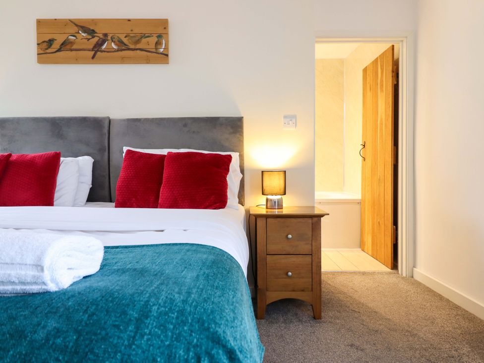 A bedroom with a bed and bedside table at Bwthyn Y Bugail (Shepherd's Cottage) Pedairffordd near Llanrhaeadr-Ym-Mochnant
