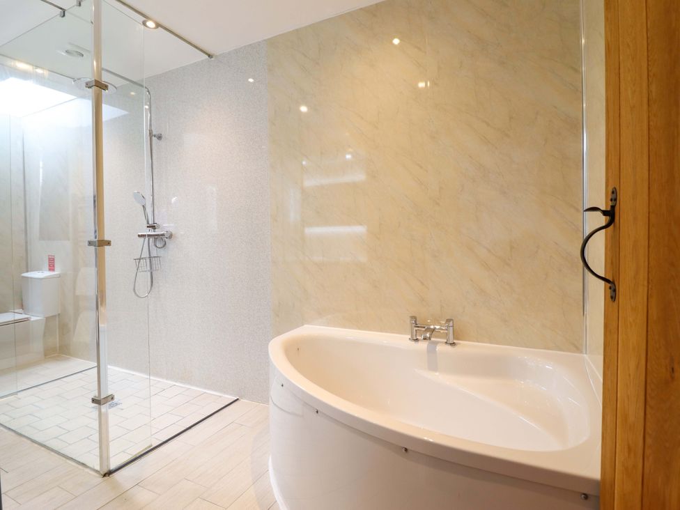 A bathroom featuring a bathtub, shower, and toilet at Bwthyn Y Bugail (Shepherd's Cottage) Pedairffordd near Llanrhaeadr-Ym-Mochnant