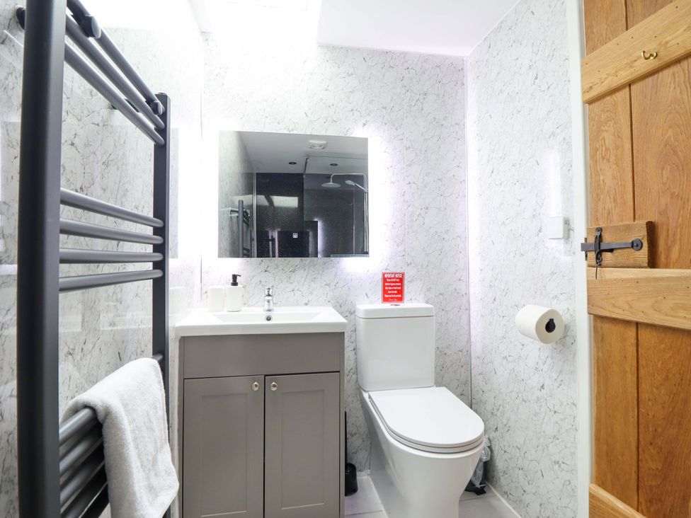 A bathroom with a sink, toilet, and towel rail at Bwthyn Y Bugail (Shepherd's Cottage) Pedairffordd near Llanrhaeadr-Ym-Mochnant