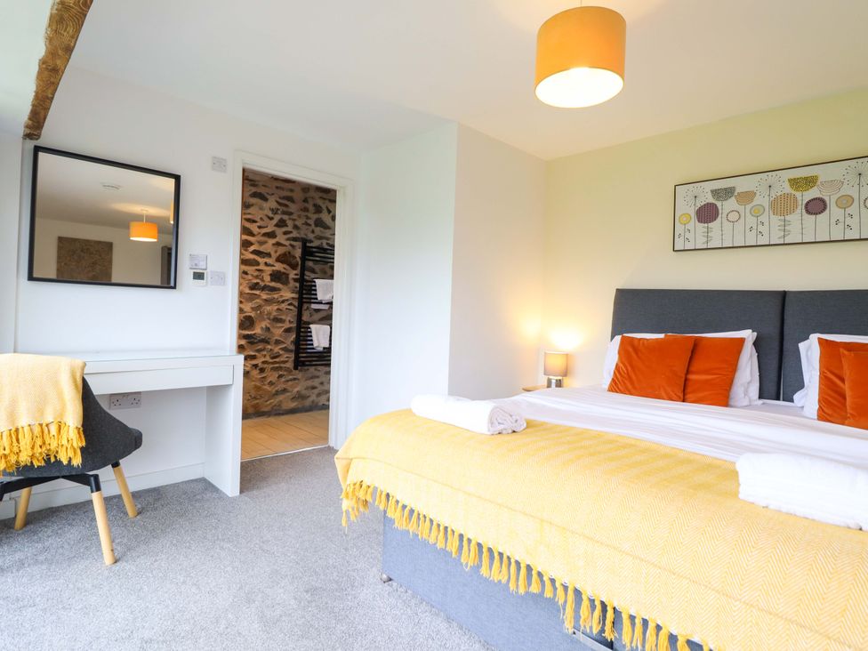 A bedroom with a bed and desk at Bwthyn Y Bugail (Shepherd's Cottage) Pedairffordd near Llanrhaeadr-Ym-Mochnant