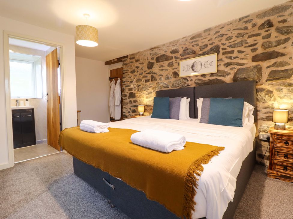 A bedroom with a bed and bedside tables at Bwthyn Y Bugail (Shepherd's Cottage) Pedairffordd near Llanrhaeadr-Ym-Mochnant
