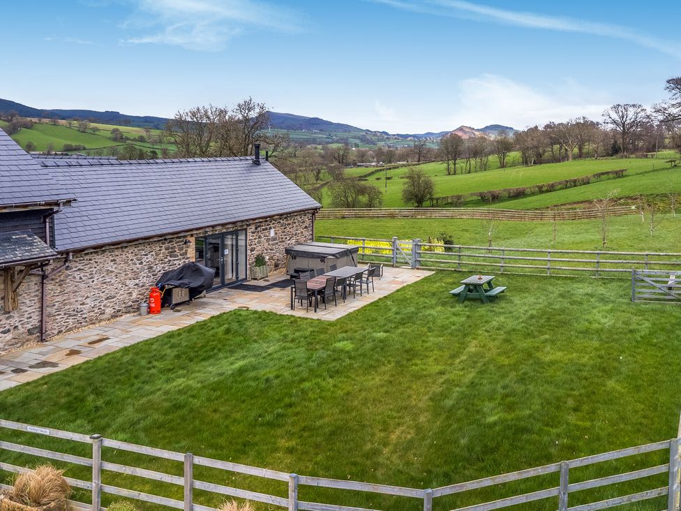 An outdoor patio area with a table and chairs at Bwthyn Y Bugail (Shepherd's Cottage) Pedairffordd near Llanrhaeadr-Ym-Mochnant