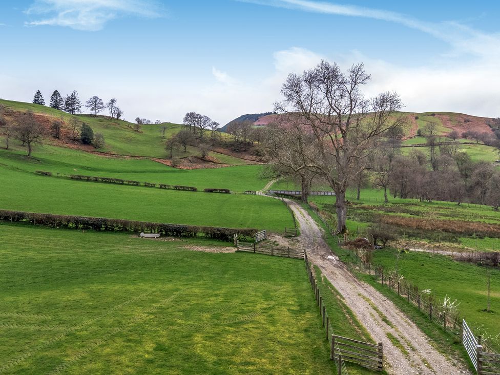 A field with a path and trees at Y Beudy (The Dairy) Pedairffordd near Llanrhaeadr-Ym-Mochnant